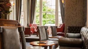 A room with leather chairs and a sofa, large windows with curtains, and a patterned wall. - Hotel Bannatyne Darlington (Darlington)
