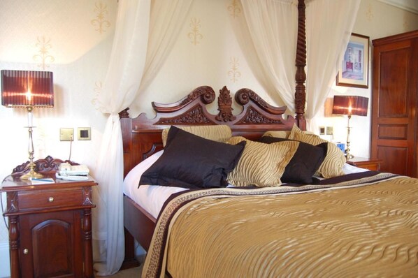 A four-poster bed with a canopy, a bedside table with a lamp, and a wooden wardrobe. - Hotel Bannatyne Darlington (Darlington)