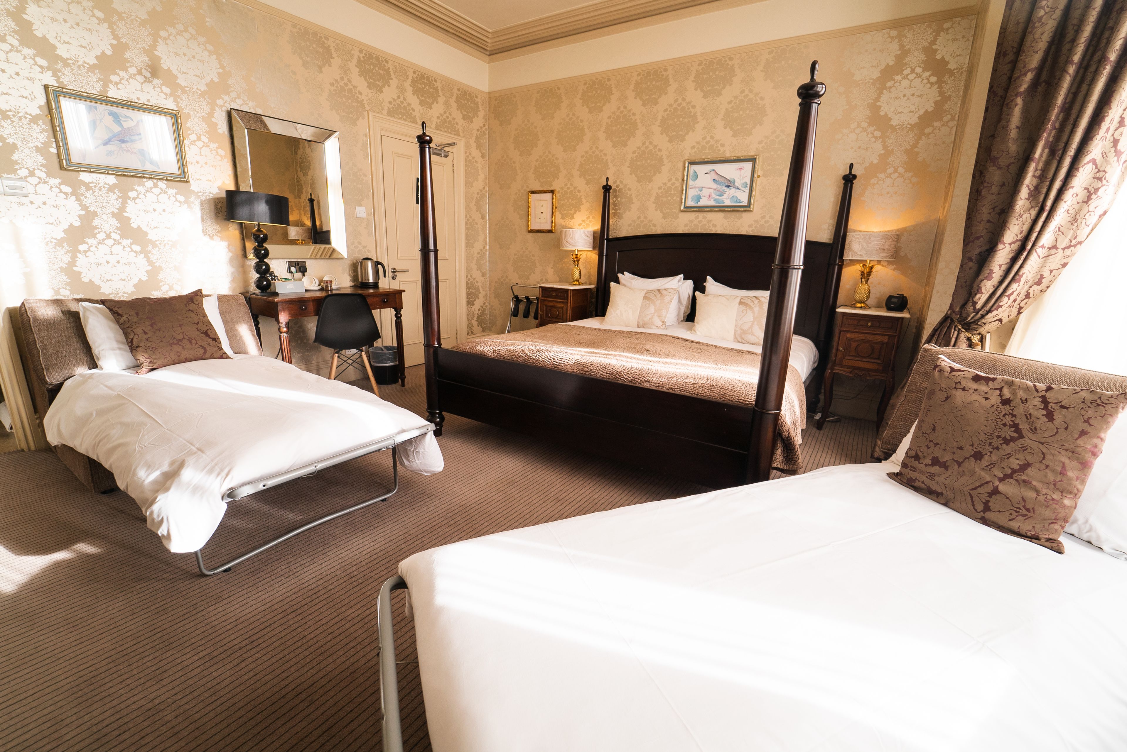 Ein Hotelzimmer mit zwei Betten, einem Schreibtisch, einem Stuhl, einem Kleiderschrank und einem Badezimmer.