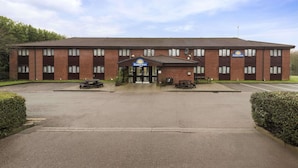 A Days Inn with a brick facade, a central entrance, and a parking lot.