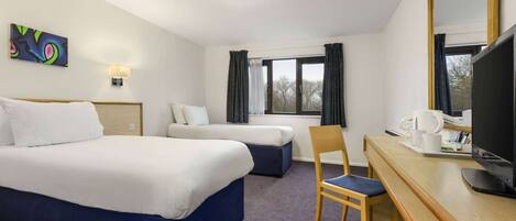 A hotel room with two beds, a desk with a chair, a television, and a window with curtains.