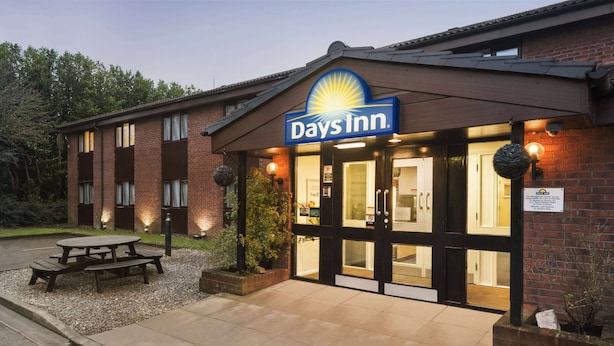 A Days Inn with a brick facade, large windows, and a well-lit entrance.