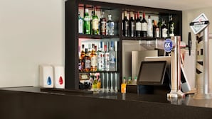 Angolo bar con scaffali pieni di bottiglie di liquori, un rubinetto per la birra Beck's e un cartello con il numero 6.