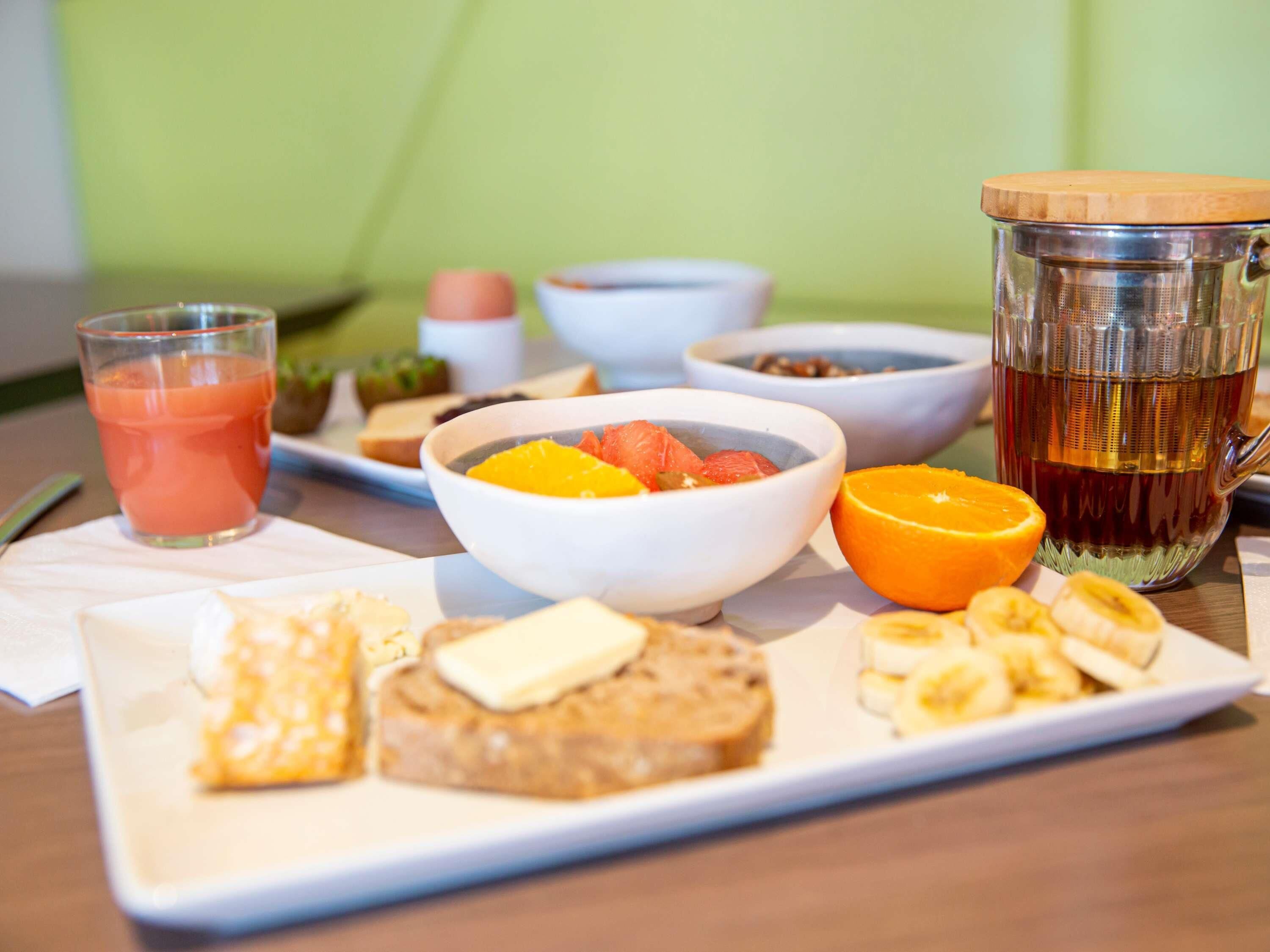 Un desayuno con tostadas, fruta y un vaso de jugo.