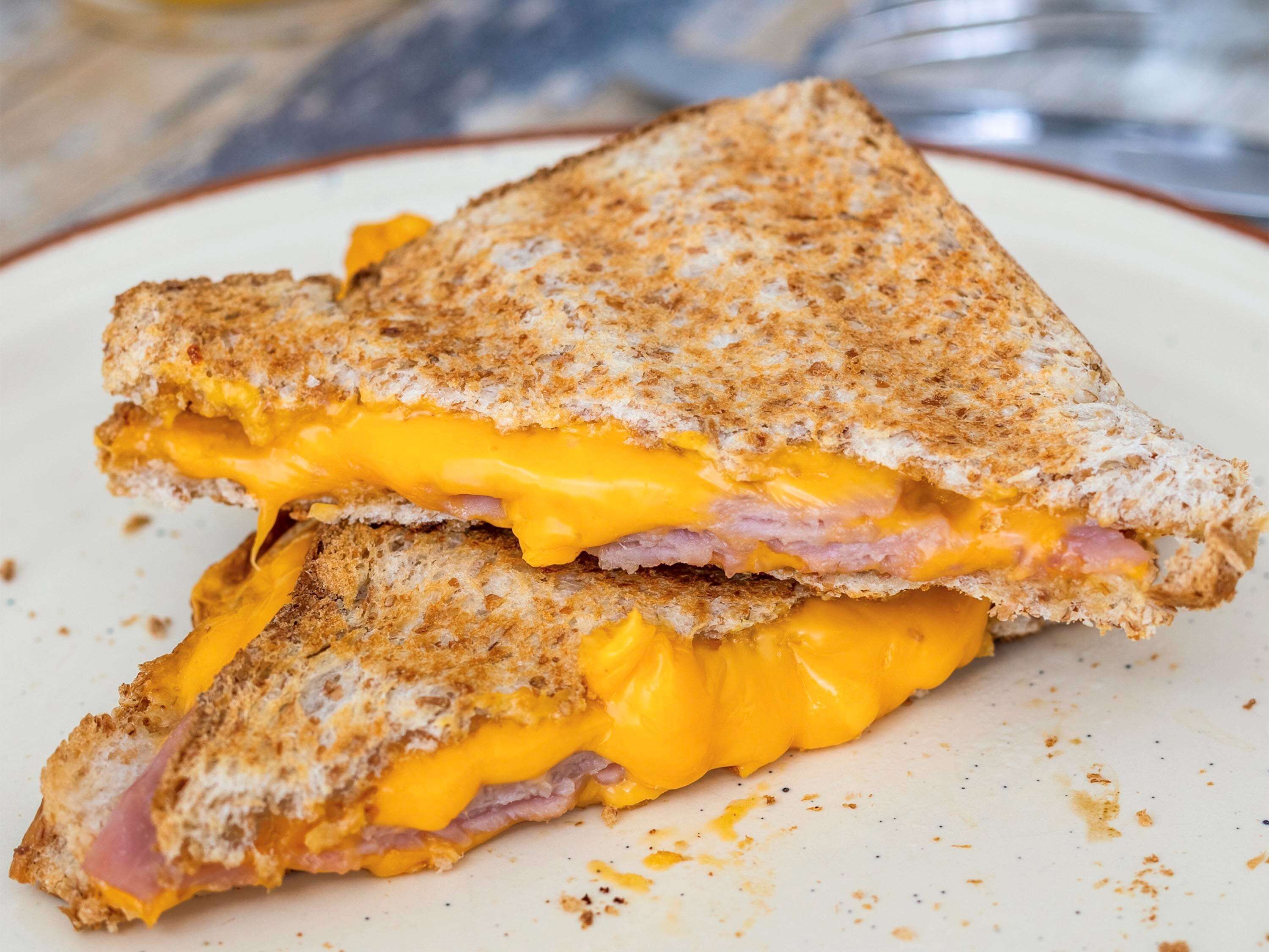 A grilled cheese sandwich with melted cheese and ham.