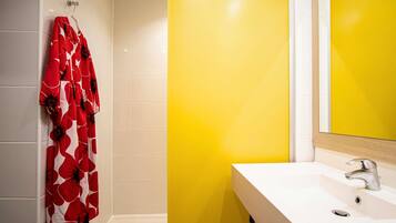 Un bagno con un lavandino bianco, uno specchio e un asciugamano rosso appeso al muro.