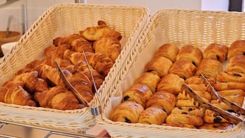 Twee rieten manden gevuld met croissants en chocoladebroodjes.