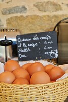 Una canasta de huevos con un cartel de pizarra que indica los precios.