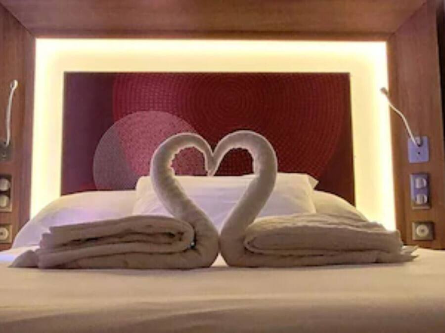 Un lit avec des serviettes disposées en forme de cœur.
