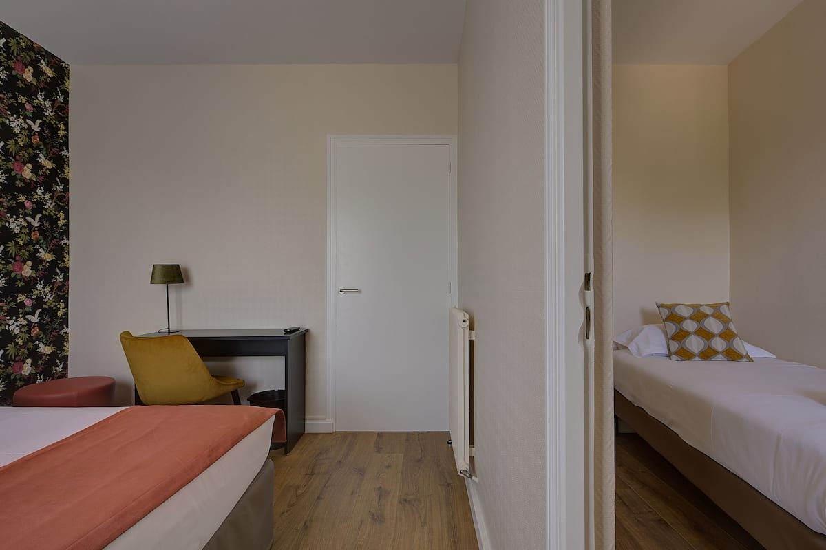 Ein Hotelzimmer mit Bett, Schreibtisch, Stuhl und Heizkörper.