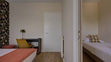 Ein Hotelzimmer mit Bett, Schreibtisch, Stuhl und Heizkörper.