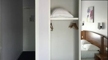 Ein Hotelzimmer mit einem Bett, einem Kleiderschrank und einem Bild an der Wand.