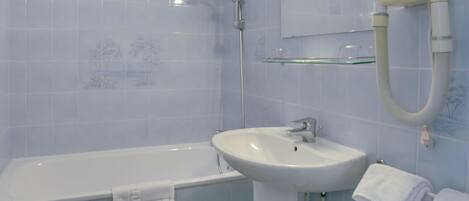 A bathroom with a bathtub, a sink, and a mirror.