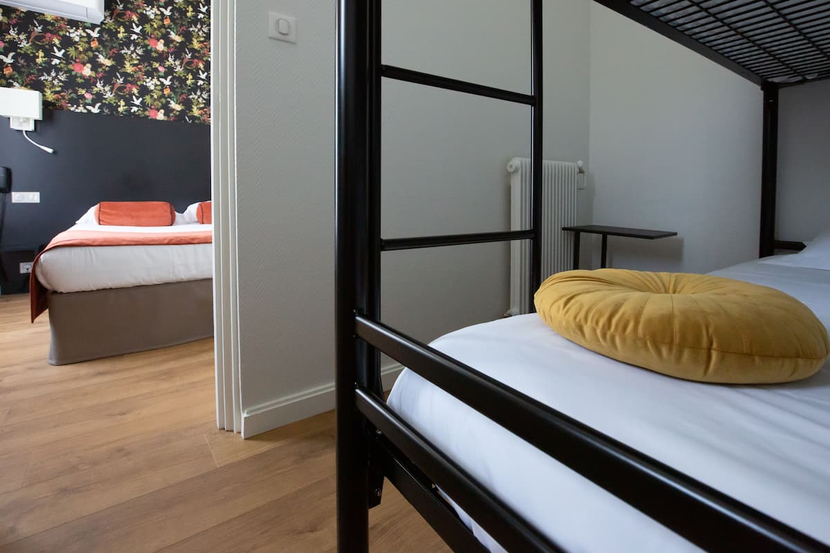 Ein Zimmer mit einem Etagenbett, einem Schreibtisch und einem Stuhl.