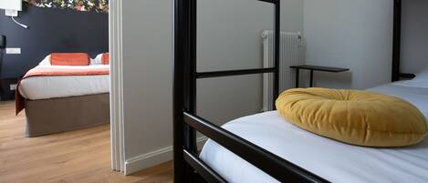 A room with a bunk bed, a desk, and a chair.