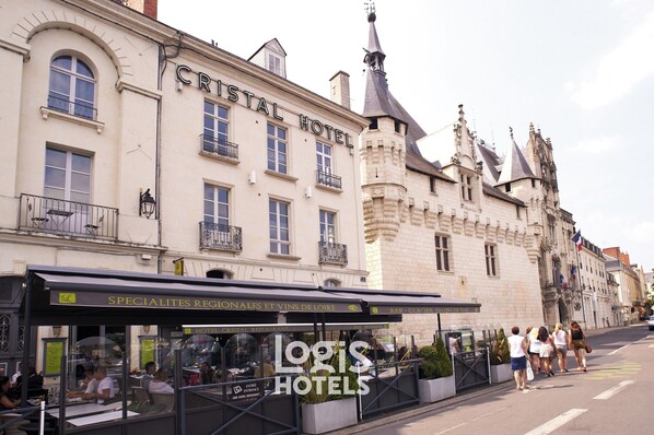 A historic building with a sign reading "CRISTAL HOTEL" and a restaurant named "SPECIALITES REGIONALES ET VINS DE LOIRE" on the ground floor. - Logis Hotel Restaurant Cristal (Saumur)