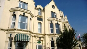 A corner building with a green awning, a sign reading "Captain's Lounge," and a flag. - Esplanade Hotel - Clacton On Sea (Beachfront Hotel) by OYO (Clacton-on-Sea)