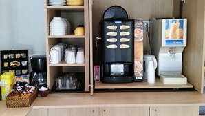 A coffee station with a coffee machine, a milk frother, and a coffee dispenser.