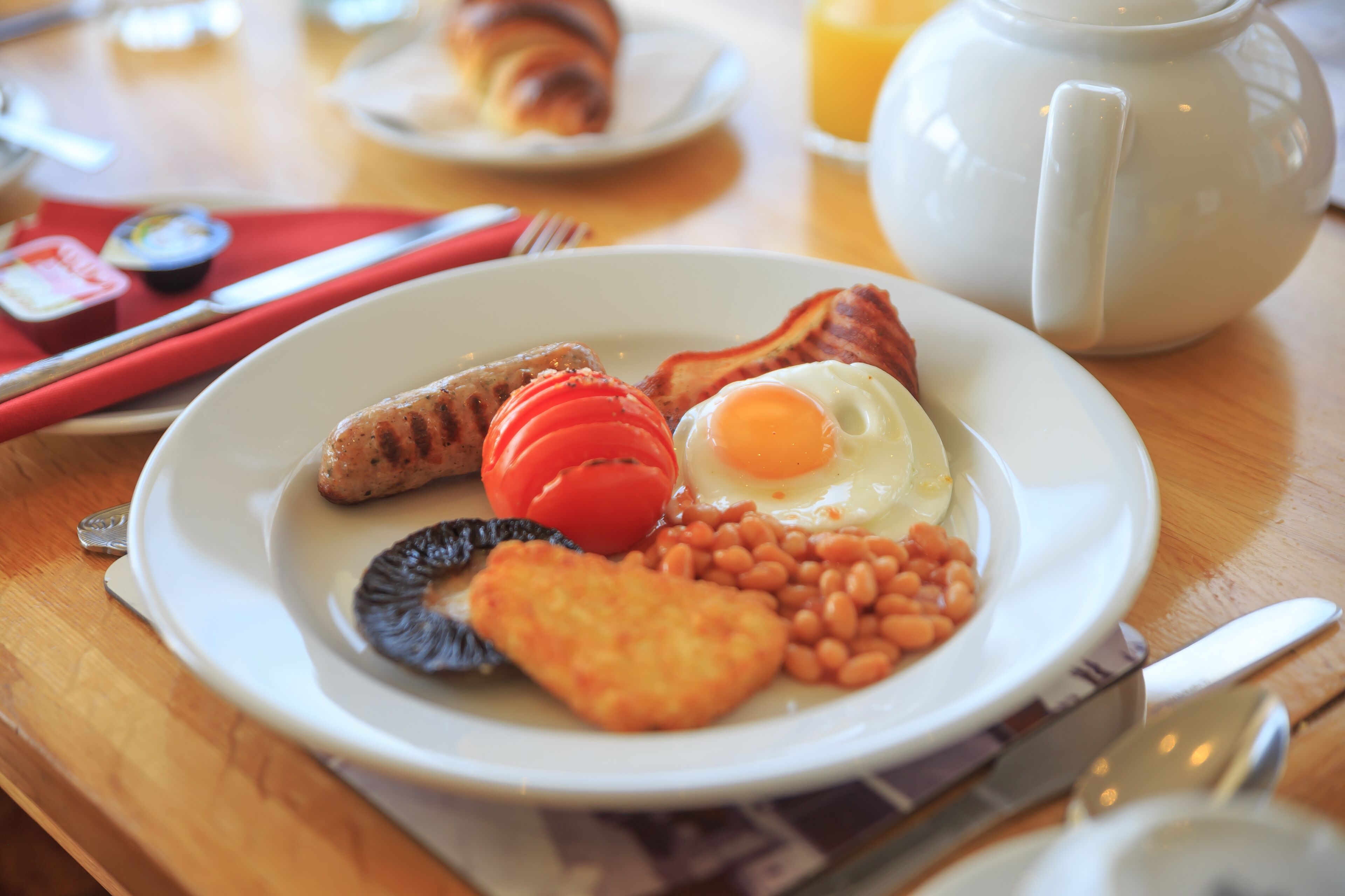 A breakfast plate with eggs, beans, tomatoes, and toast.