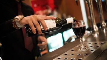 Una persona sirve vino en una copa en un bar.