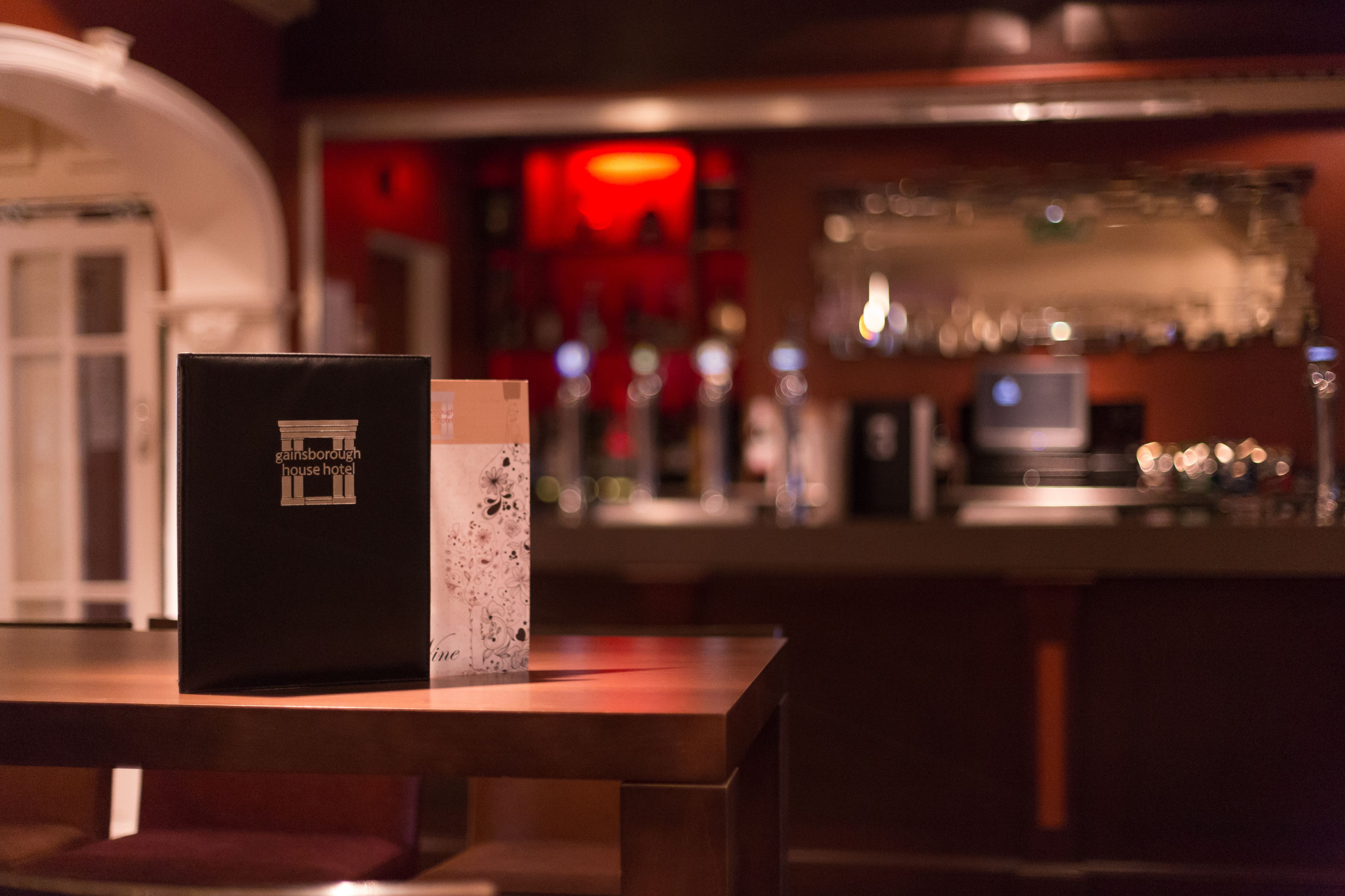 A bar area with a bar counter, glasses, and a television.