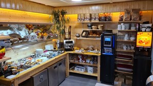 Una cafetería con paredes de madera, una máquina de café y diversos productos alimenticios exhibidos en estanterías.