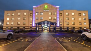 A Holiday Inn Express hotel with a brick facade, a covered entrance, and a parking lot with marked bicycle lanes. - Holiday Inn Express Poole by IHG (Poole)