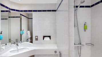 Un baño moderno con dos lavabos, ducha y espejo.