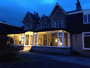 Vista frontal de la propiedad por la tarde o noche