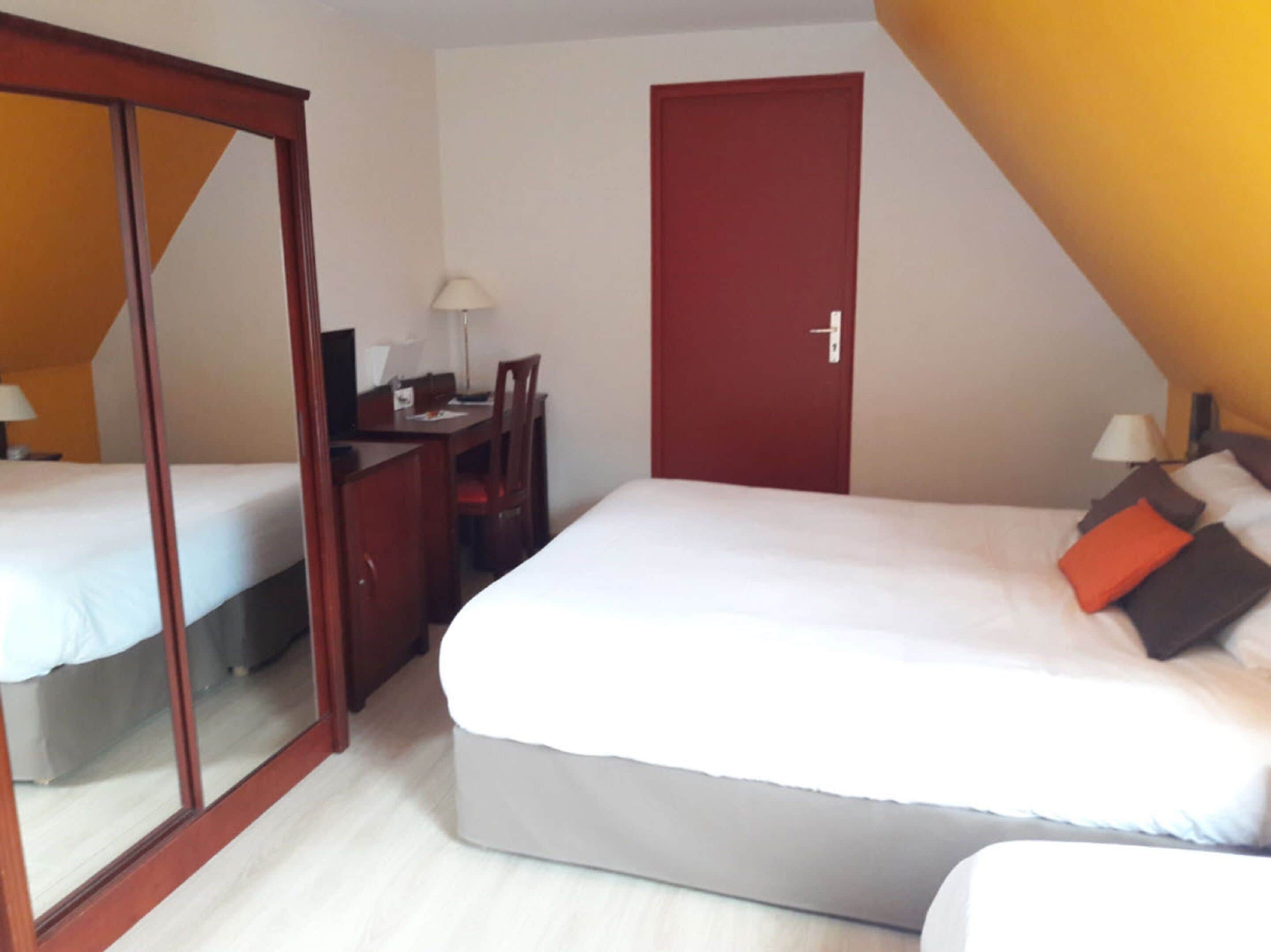 Une chambre à coucher avec un lit, un bureau et une armoire.