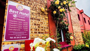 Señal de hotel con tarifas de habitaciones y un número de contacto.