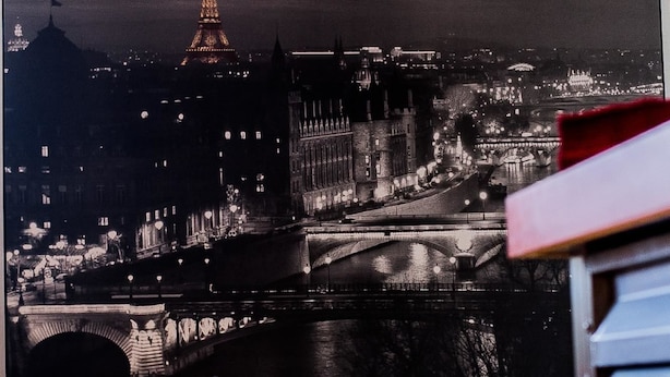 Fotografía blanco y negro de un paisaje urbano nocturno, con puntos de referencia iluminados y un puente.