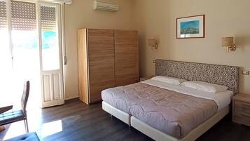 A bedroom with a bed, wardrobe, and a desk.