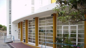 A building with a white exterior, yellow columns, and large windows.