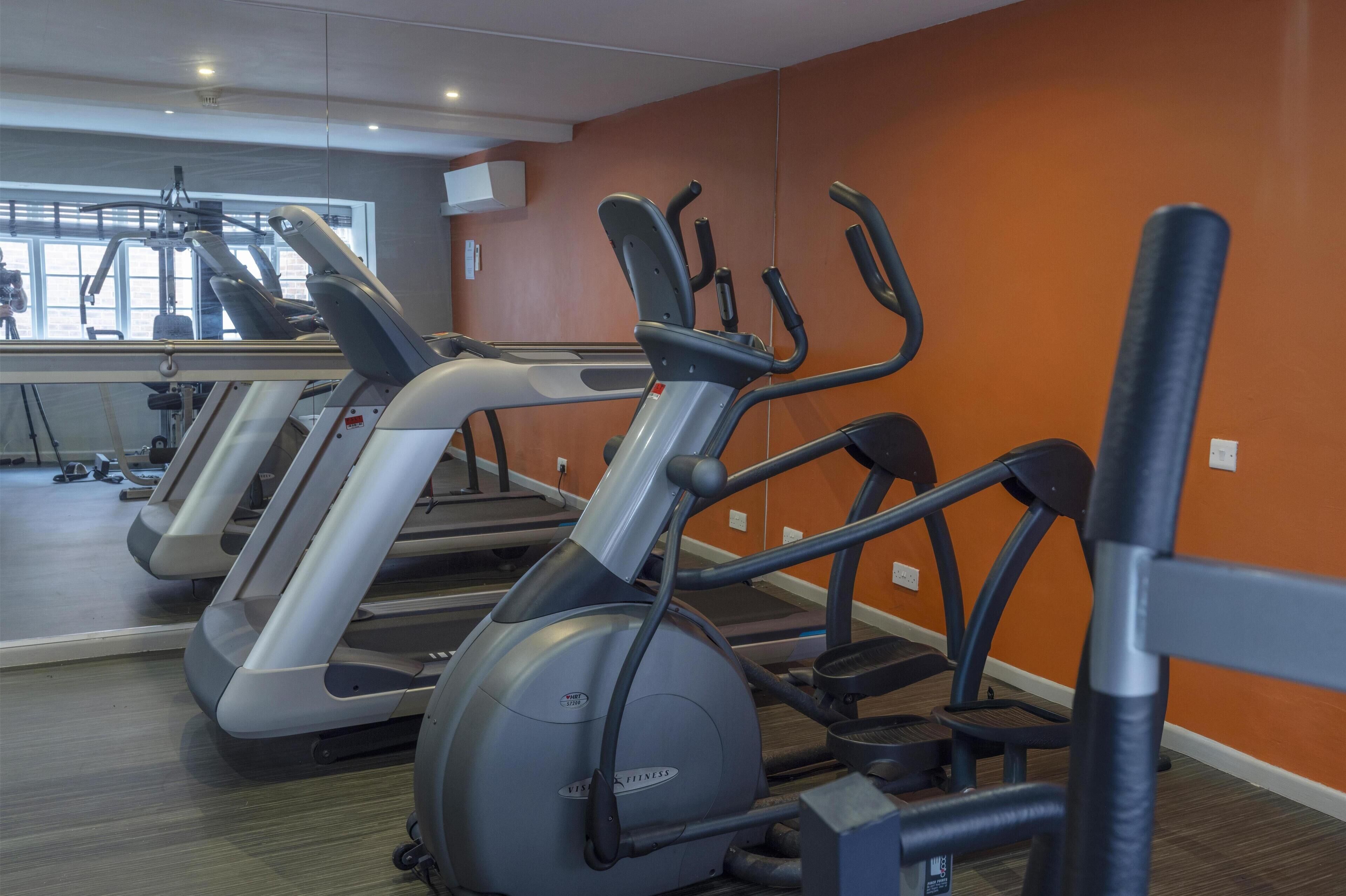 A gym with multiple treadmills and exercise equipment.