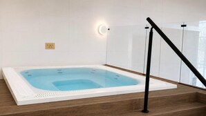 A hot tub on a wooden staircase with a glass railing and a wall-mounted light. - The Wiltshire Hotel, Golf and Leisure Resort (Swindon)