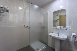 A modern bathroom with a glass-enclosed shower, a white sink, and a mirror above it. - Hotel Sur Málaga (Málaga)