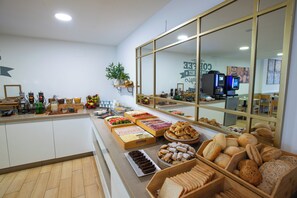 A buffet area with various food items and a large window. - Hotel Sur Málaga (Málaga)