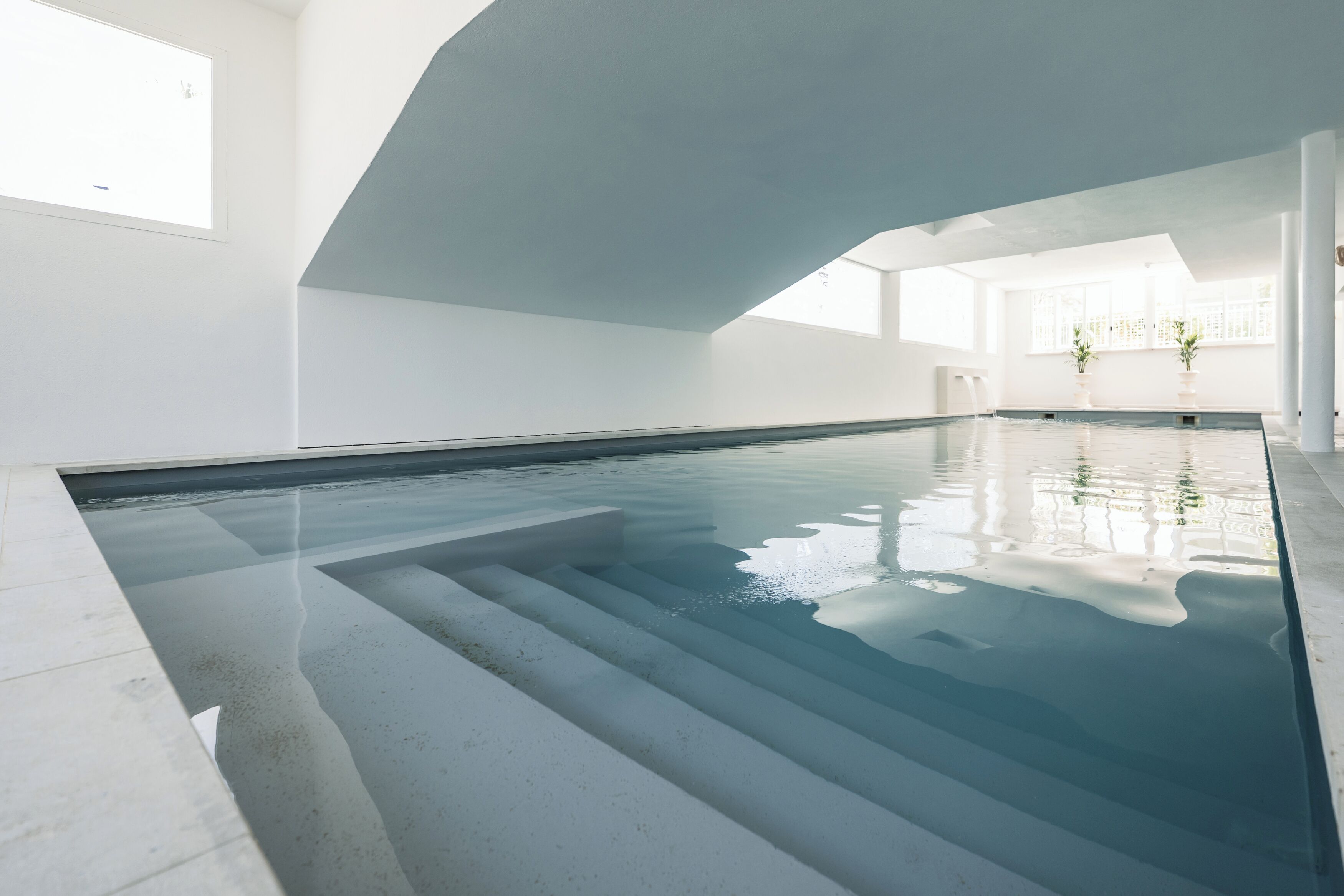 Piscine couverte, piscine avec cascade, chaises longues