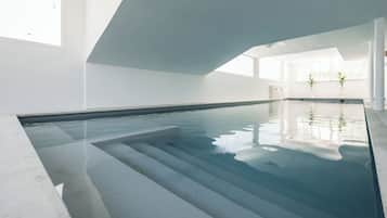 Piscine couverte, piscine avec cascade, chaises longues