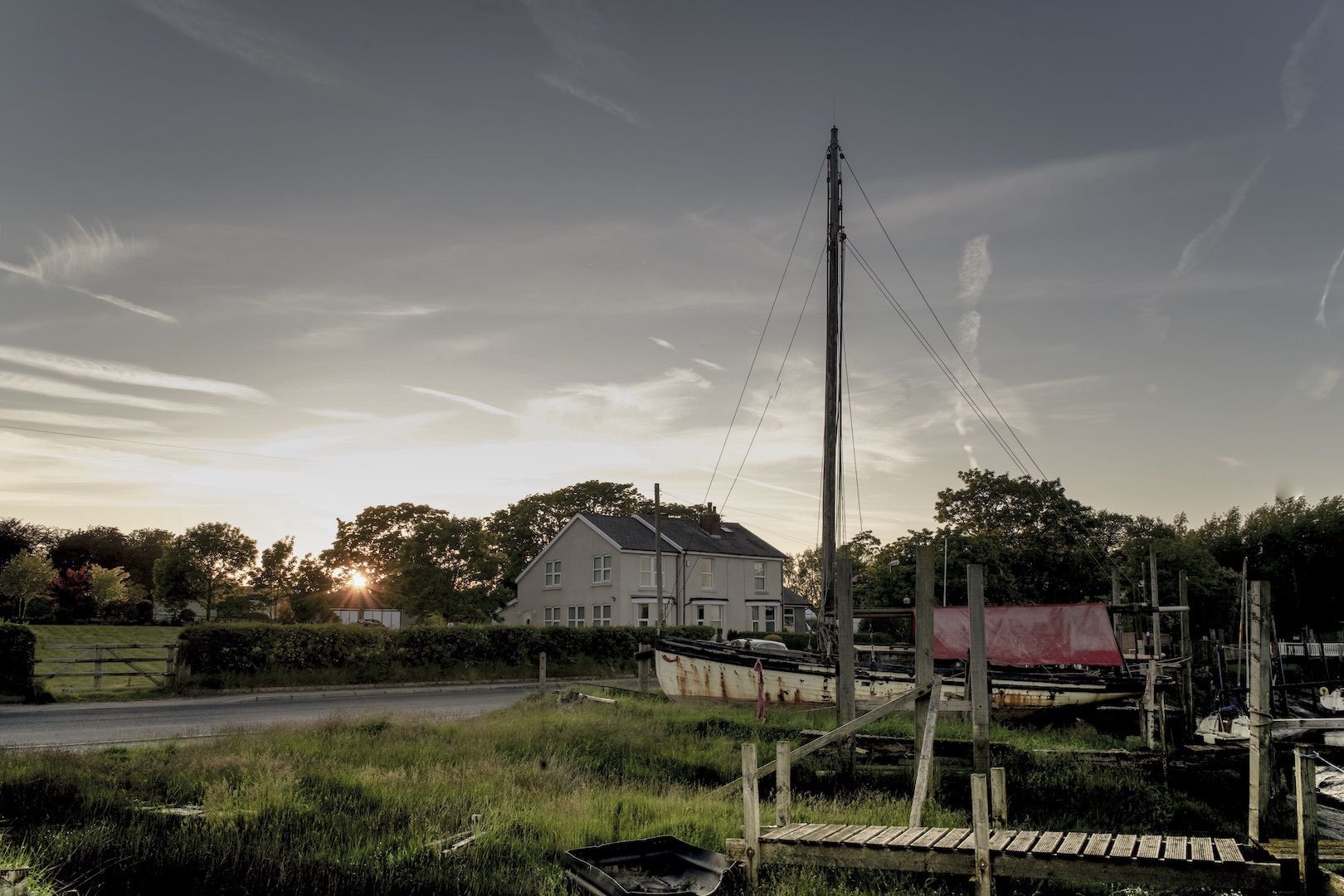A house with a large yard, a dock, and a utility pole.
