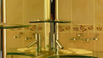 A bathroom with a glass sink and a mirror above it.