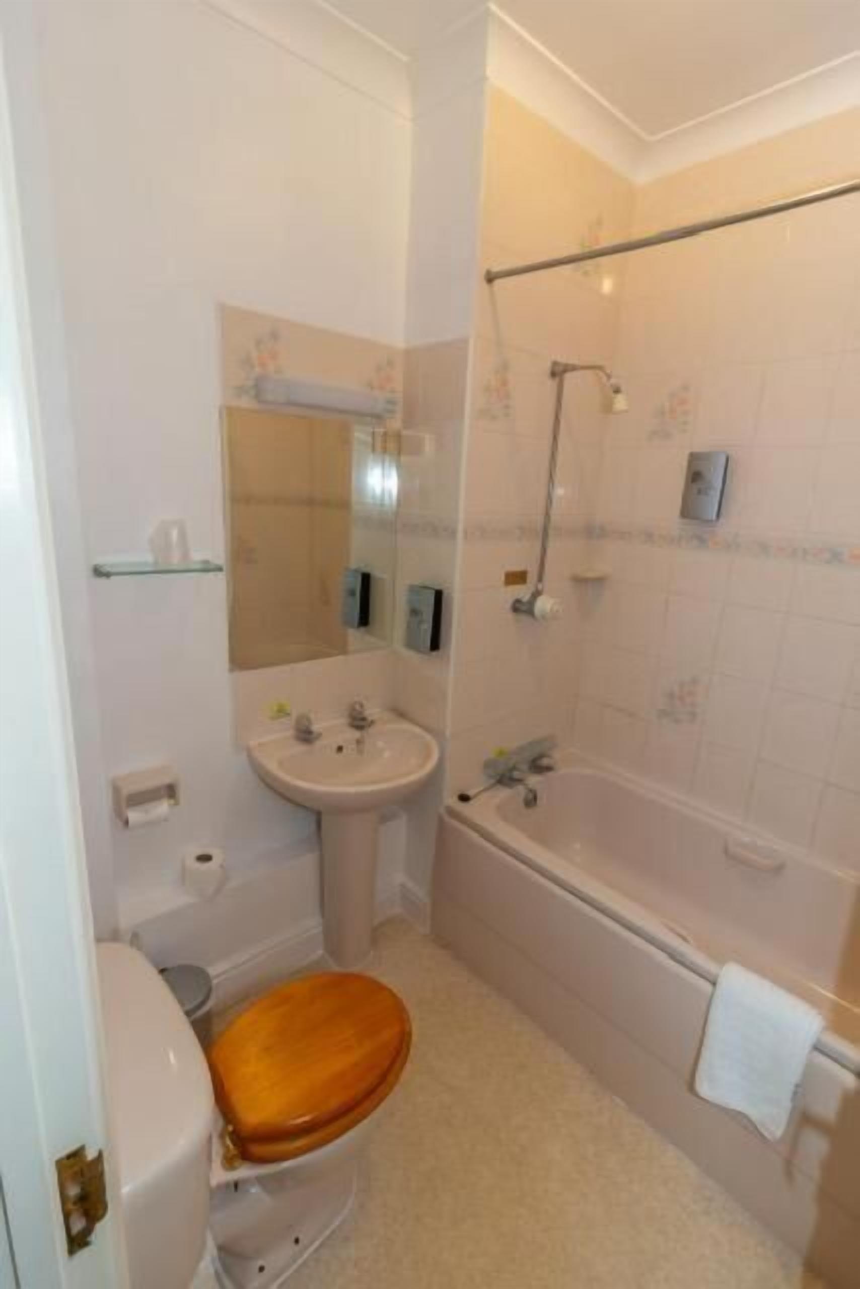A bathroom with a toilet, sink, and bathtub.