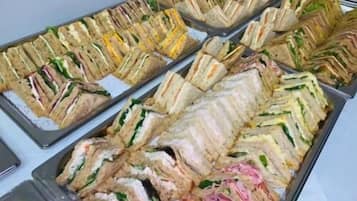 A buffet with various sandwiches arranged on trays.