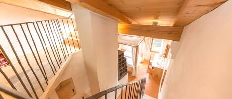 A wooden staircase with a metal railing leading to a lower level.