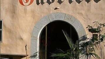 Een gebouw met de naam 'San Gabriel' in grote letters boven een gebogen ingang.