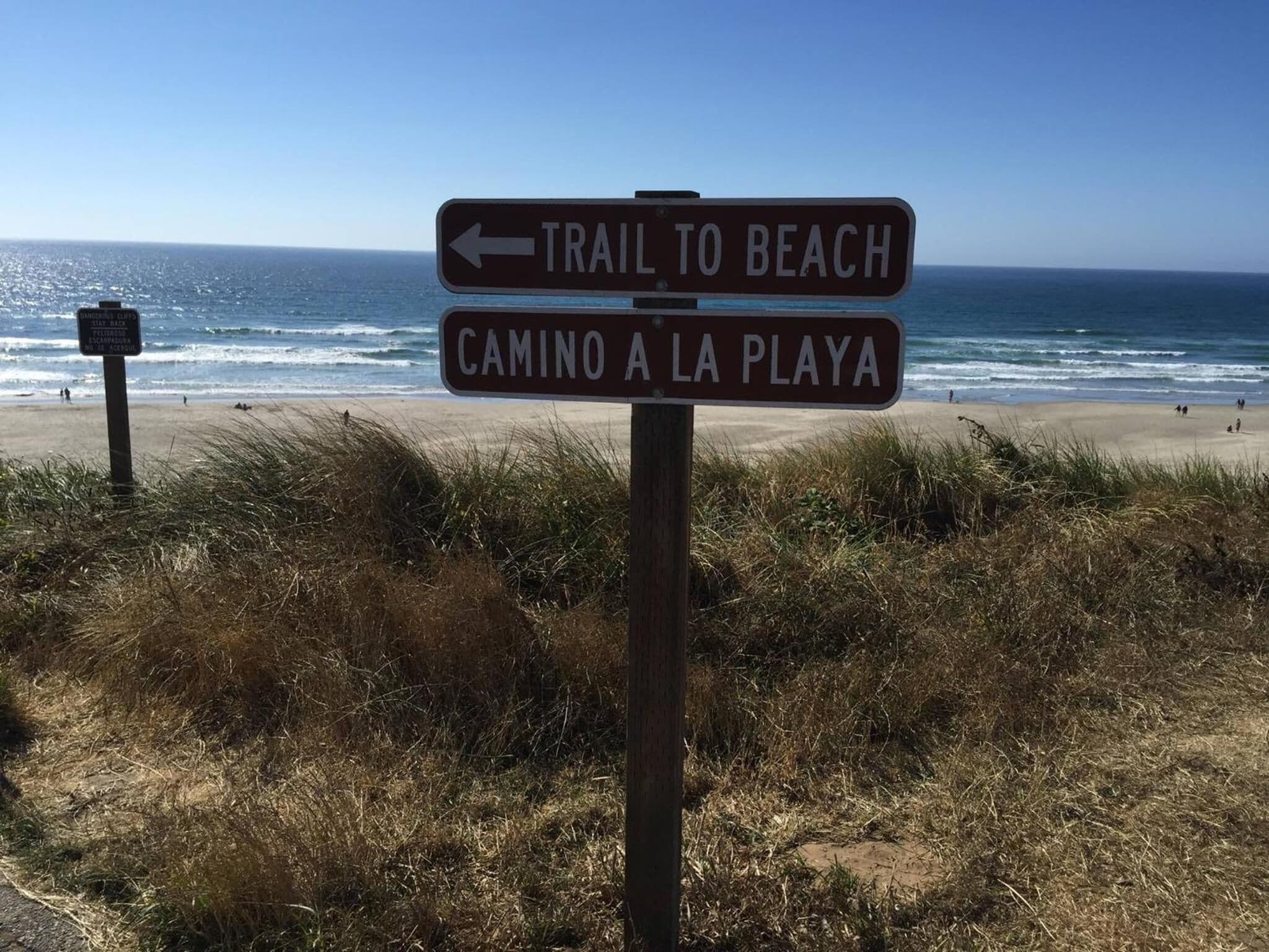 A signpost with directions to a beach and a trail.