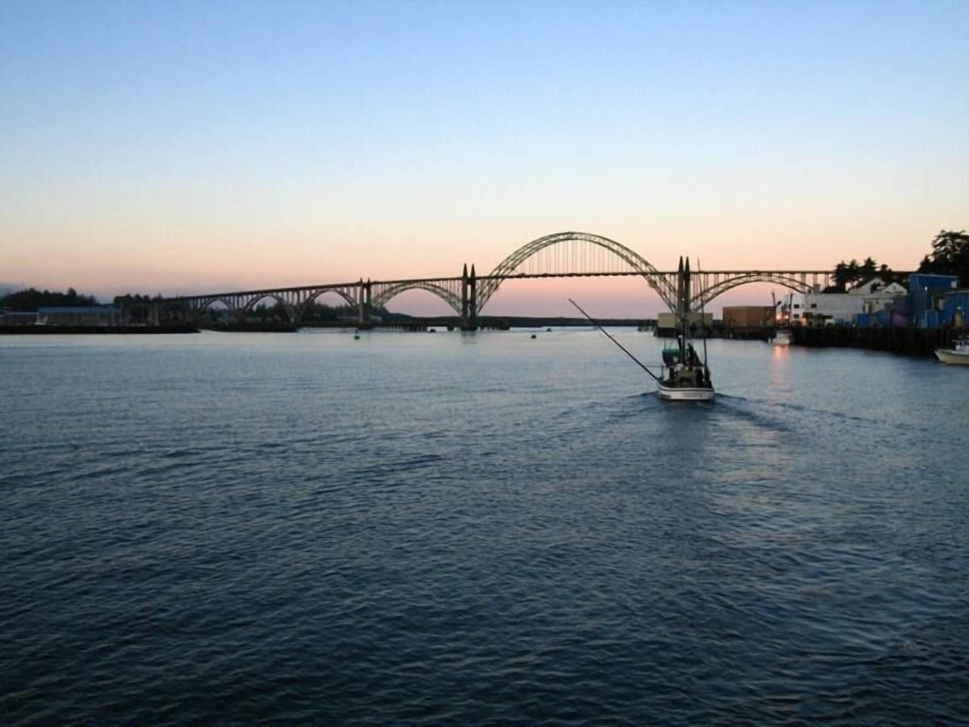 Une rivière avec un bateau et un pont en arrière-plan.