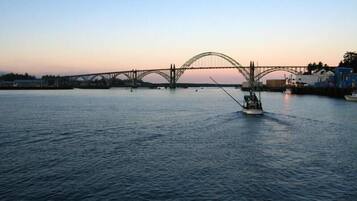 Une rivière avec un bateau et un pont en arrière-plan.