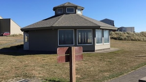 A small, single-story building with a gabled roof and a small tower-like structure on top. - Summer Wind Budget Motel (Newport)